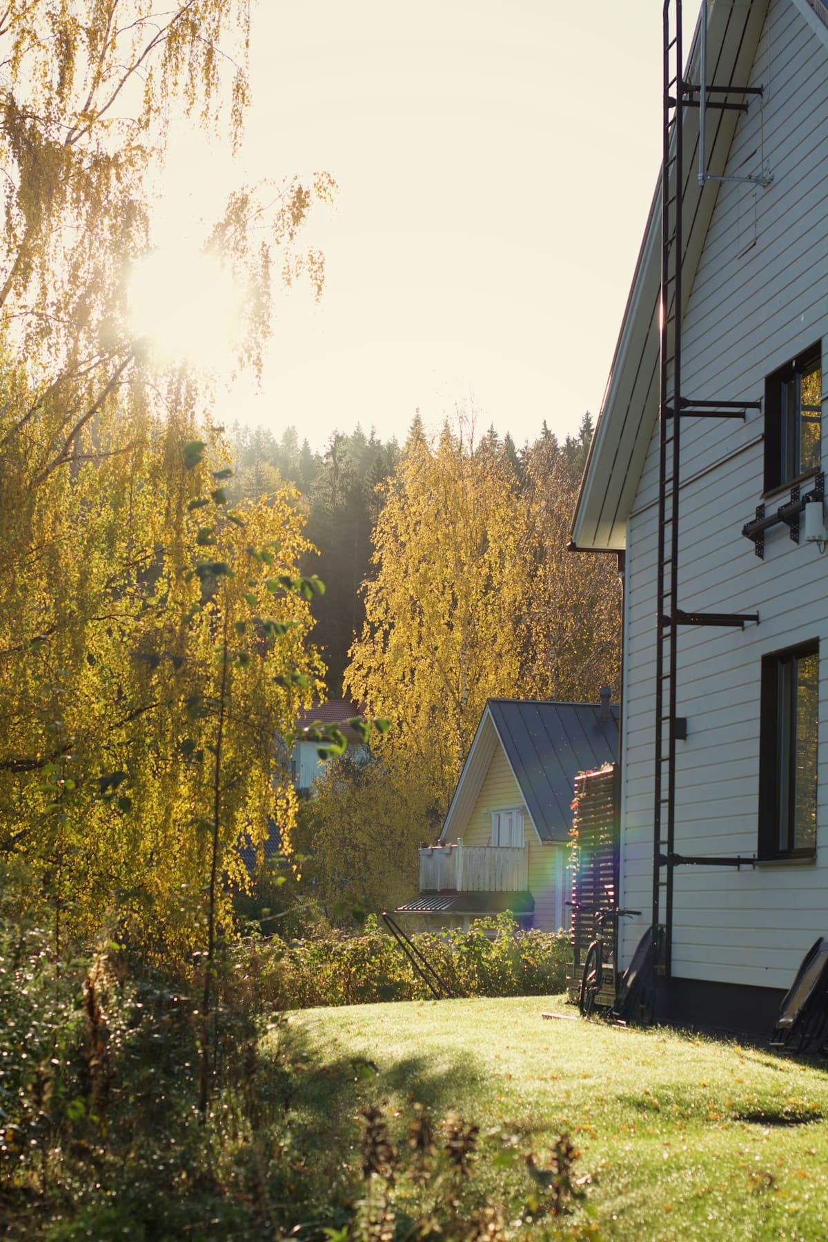 En vit villa omgiven av höstfärgade träd